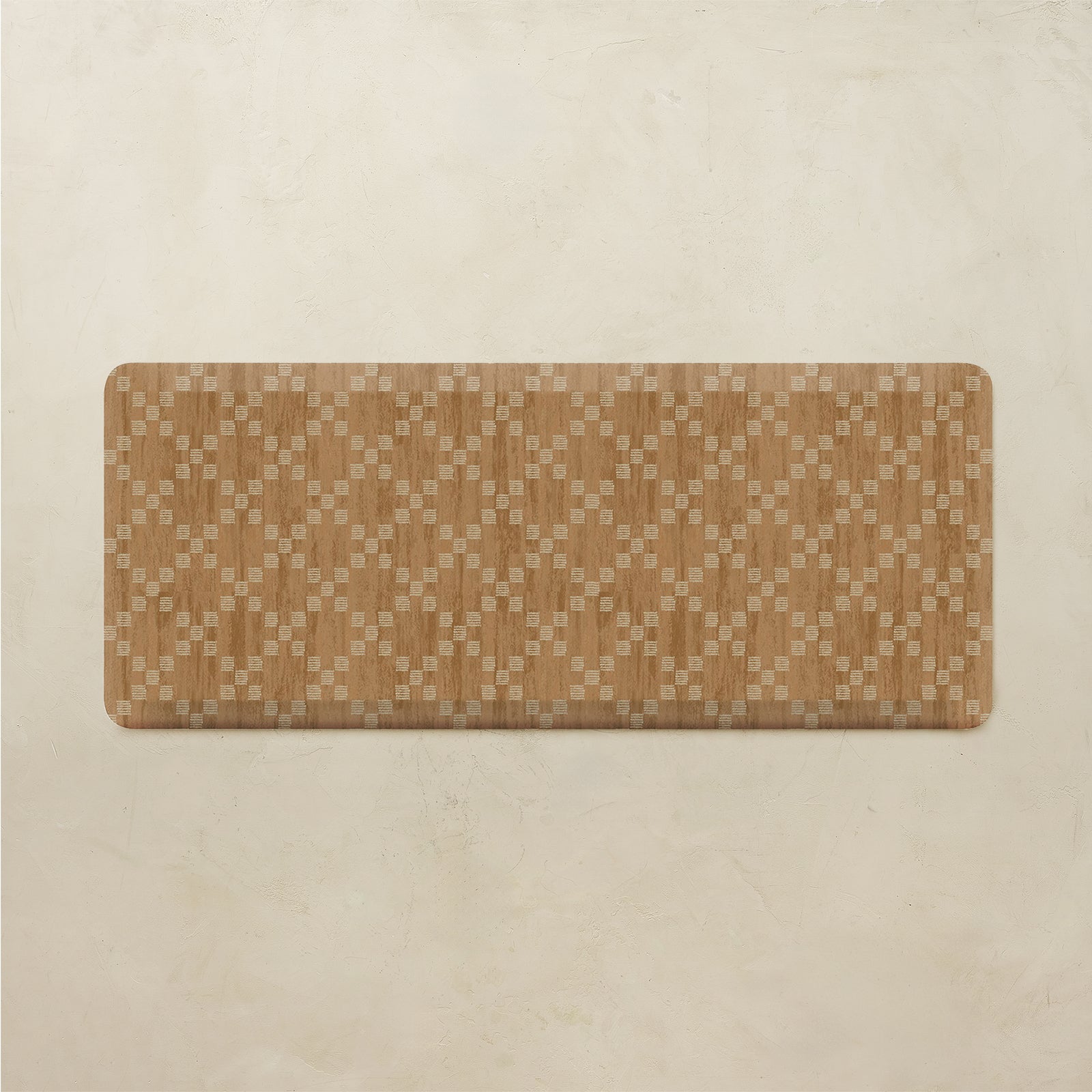 A rectangular floor mat with rounded corners, featuring a woven geometric pattern in shades of brown and beige, displayed on a textured beige background.