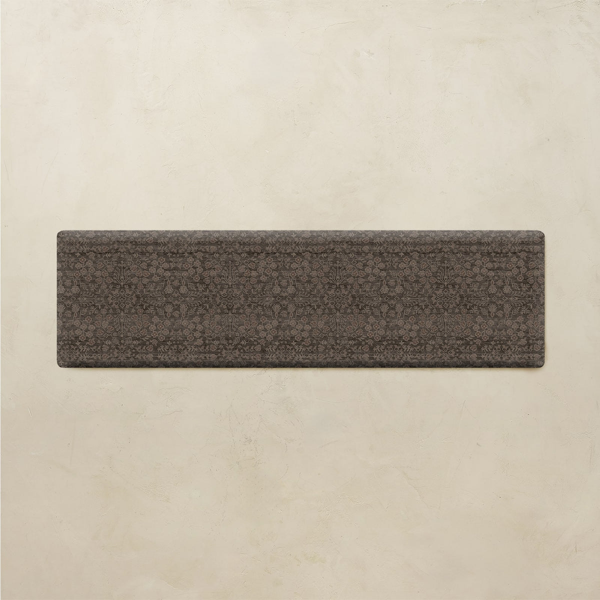 A rectangular dark brown textured tile or slab with a subtle repeating floral pattern, displayed against a light beige textured background.