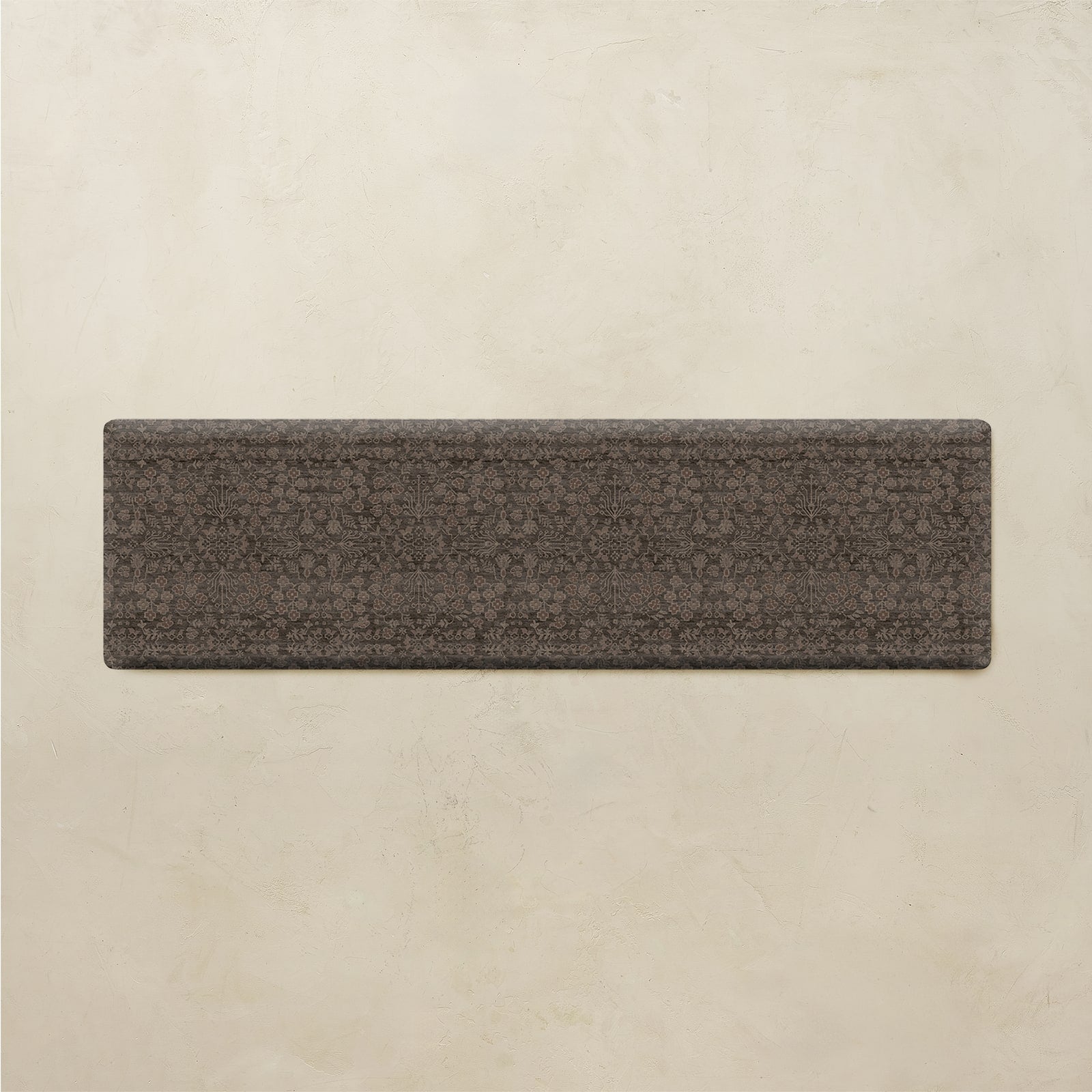 A rectangular dark brown textured tile or slab with a subtle repeating floral pattern, displayed against a light beige textured background.