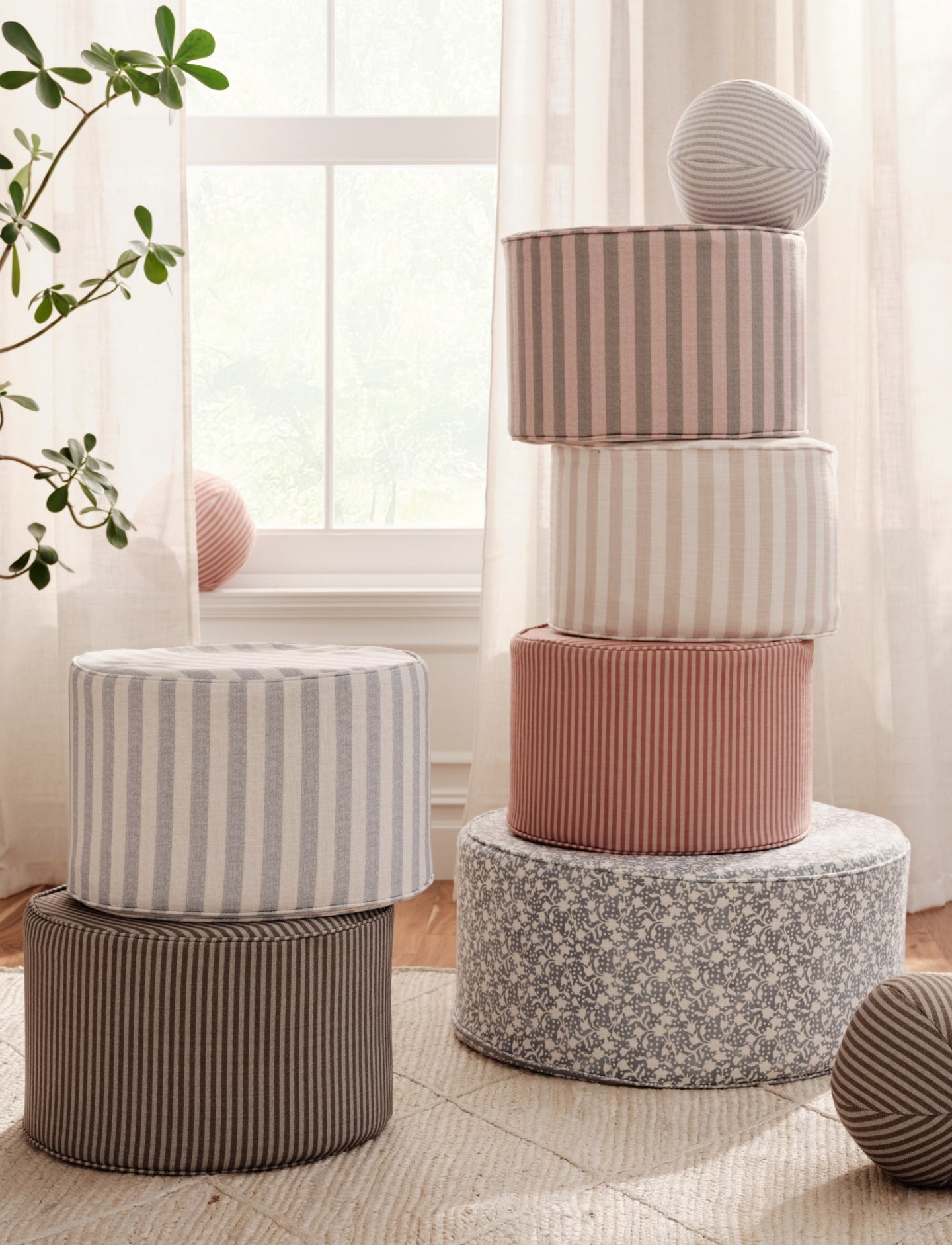 Stack of ottomans with striped and floral designs in a child's play room