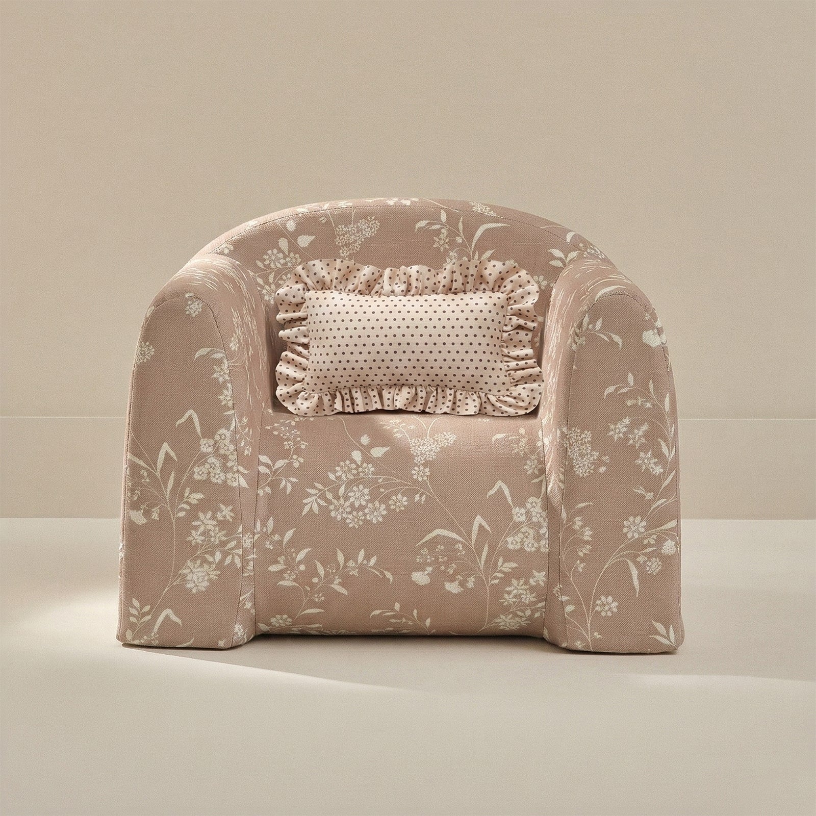 Floral-patterned armchair with a decorative pillow on a neutral background
