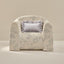 Floral-patterned armchair with a decorative pillow on a beige background