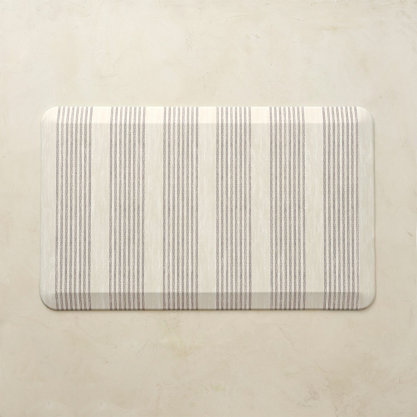 Rectangular kitchen mat with neutral striped pattern on a beige background