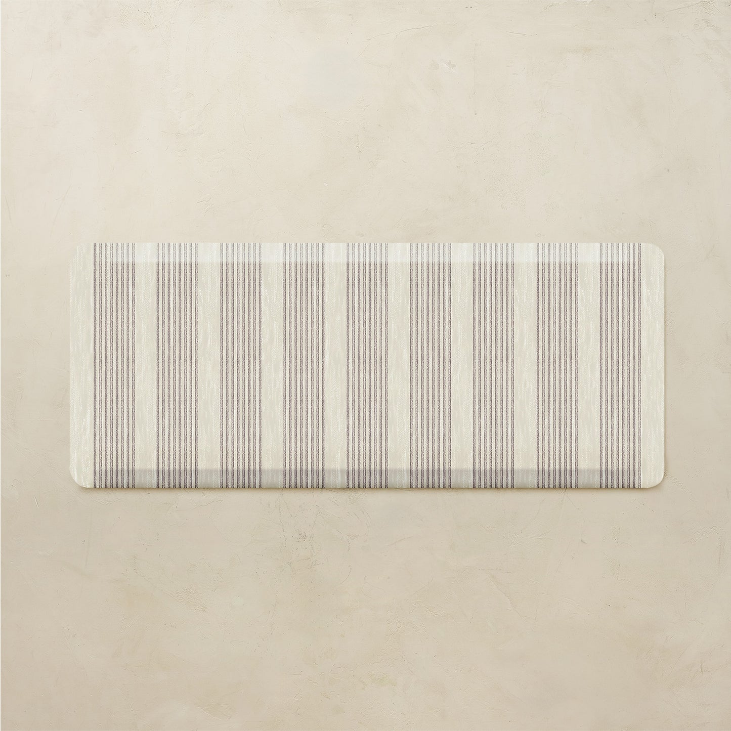 Rectangular rug with subtle striped pattern on a beige background