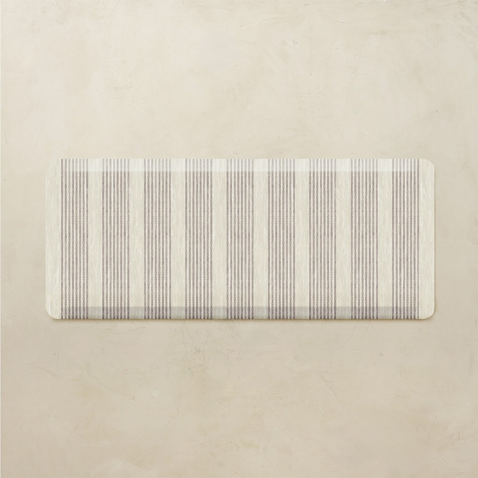 Rectangular rug with subtle striped pattern on a beige background