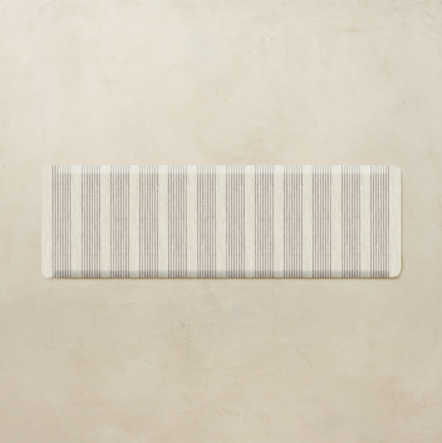 Rectangular mat with neutral horizontal striped pattern on a beige background