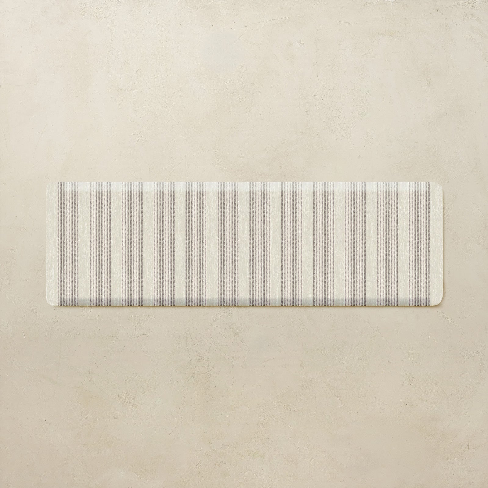 Rectangular mat with neutral horizontal striped pattern on a beige background