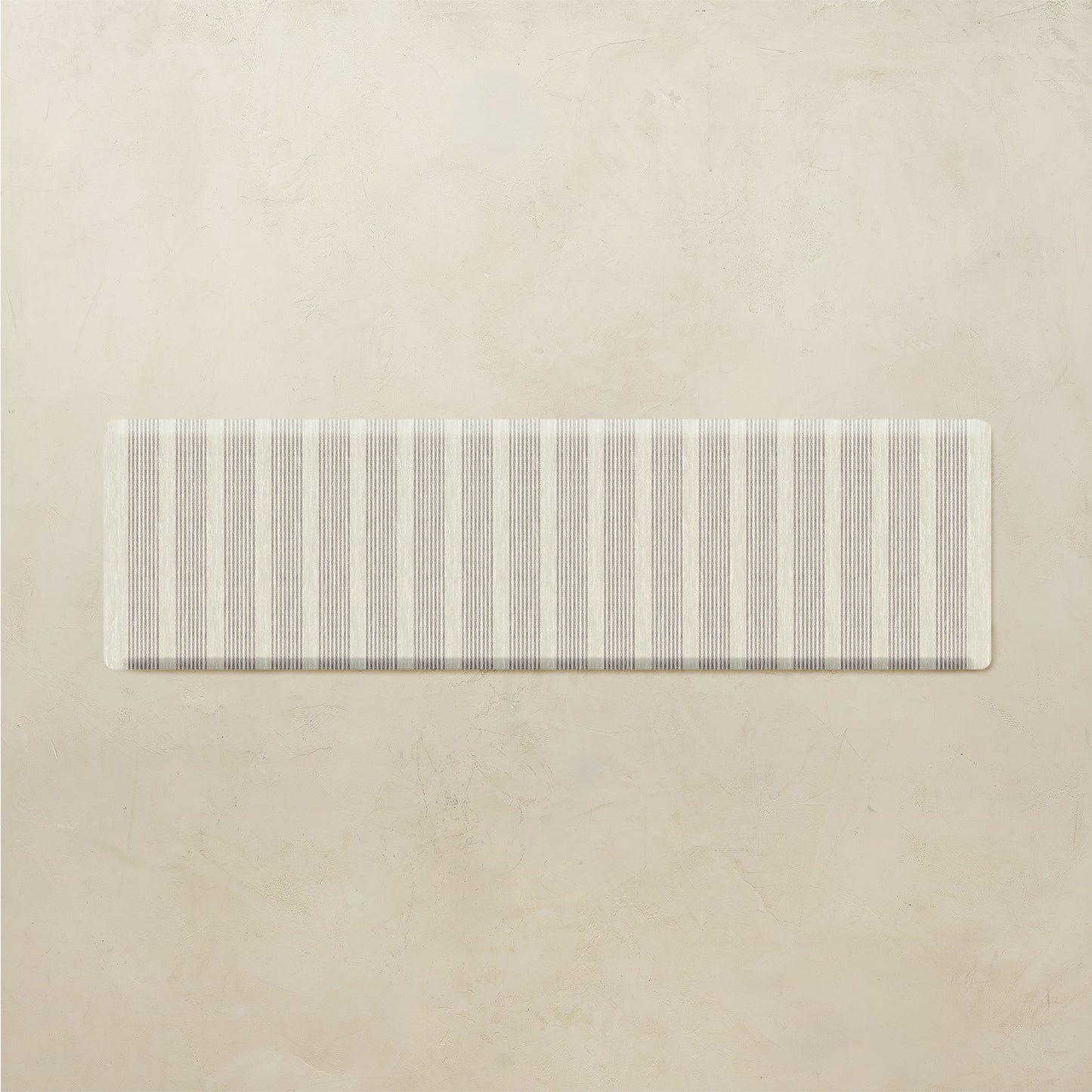 Rectangular kitchen mat with a neutral striped pattern on a beige background