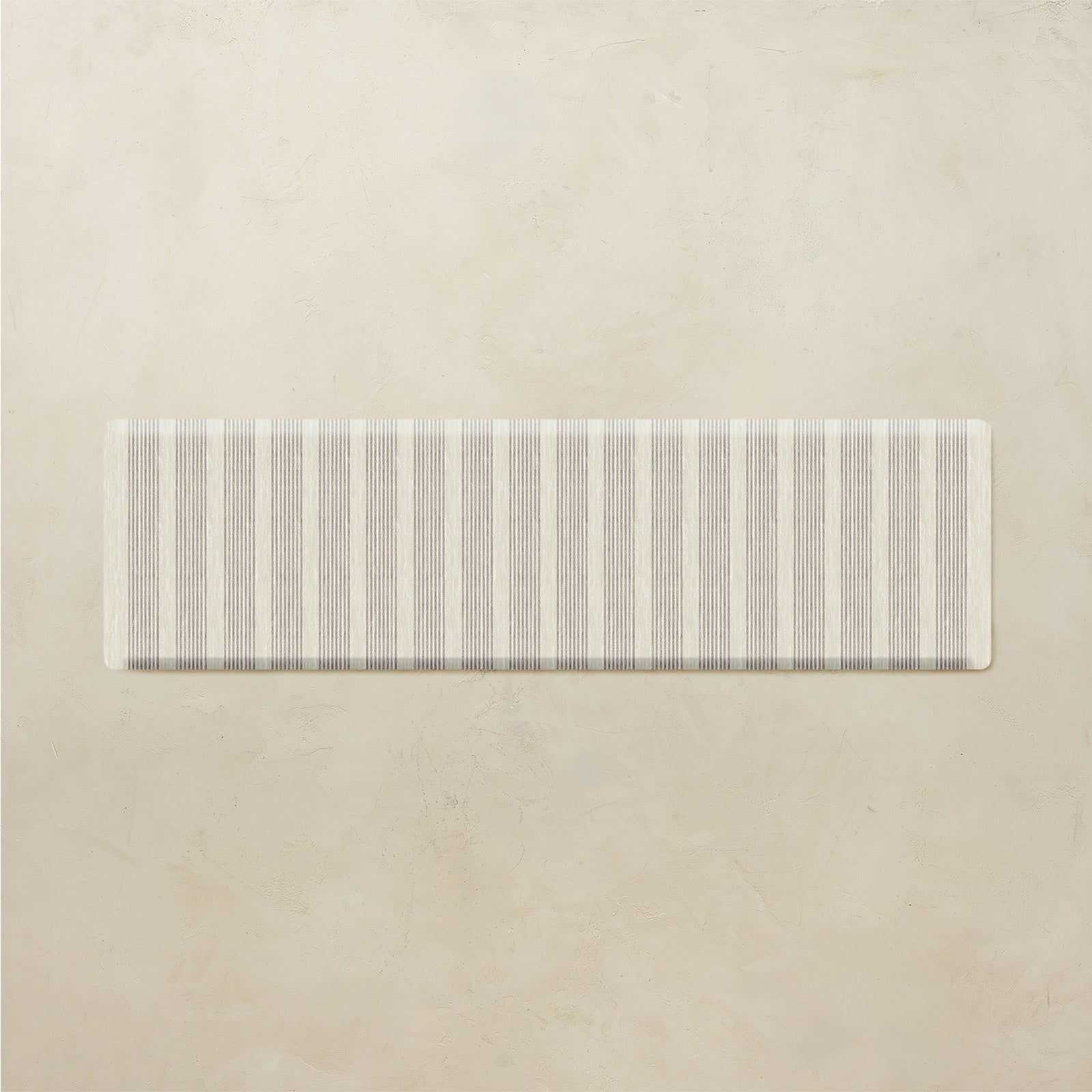 Rectangular kitchen mat with a neutral striped pattern on a beige background