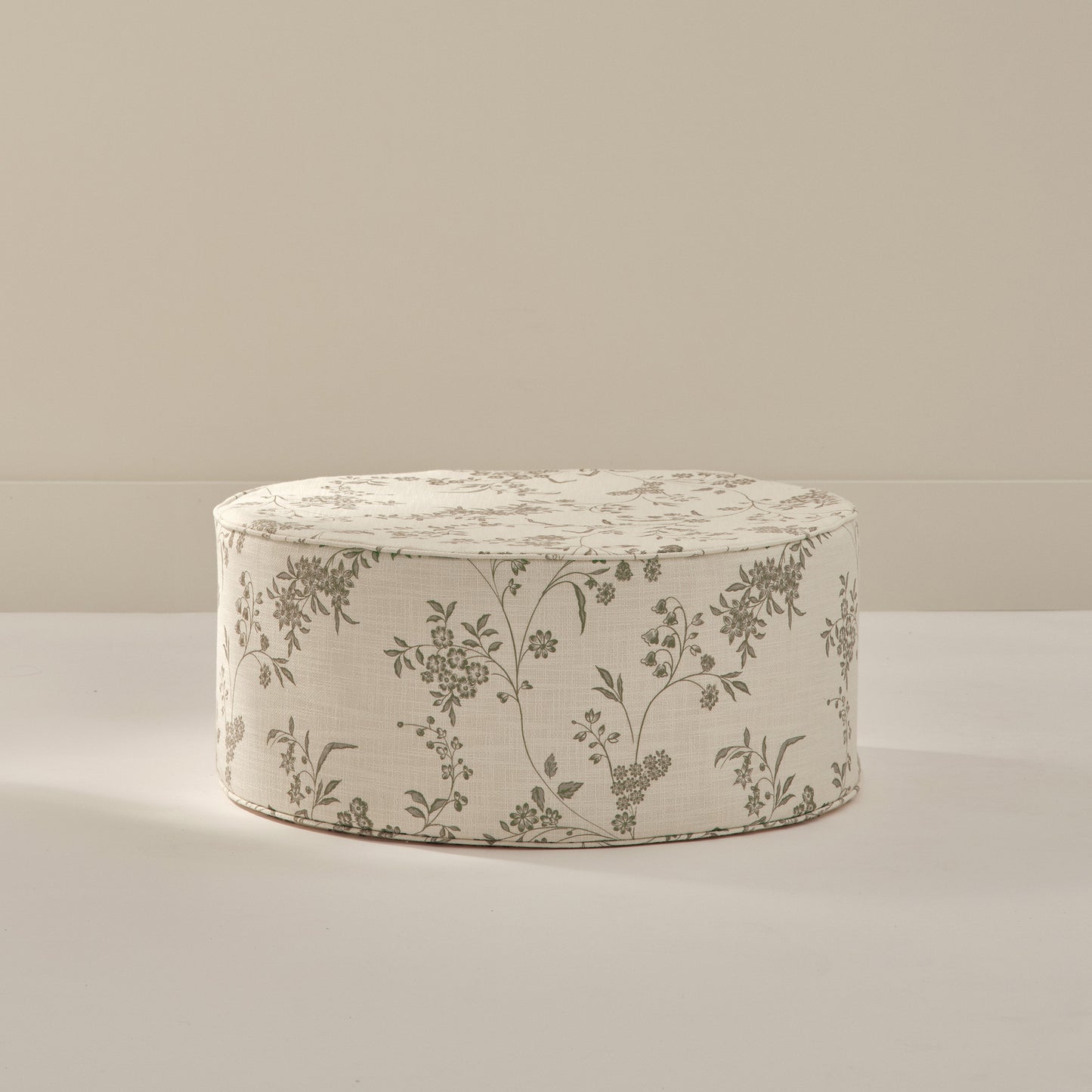 Large round foam ottoman with green and cream floral pattern from House of Noa