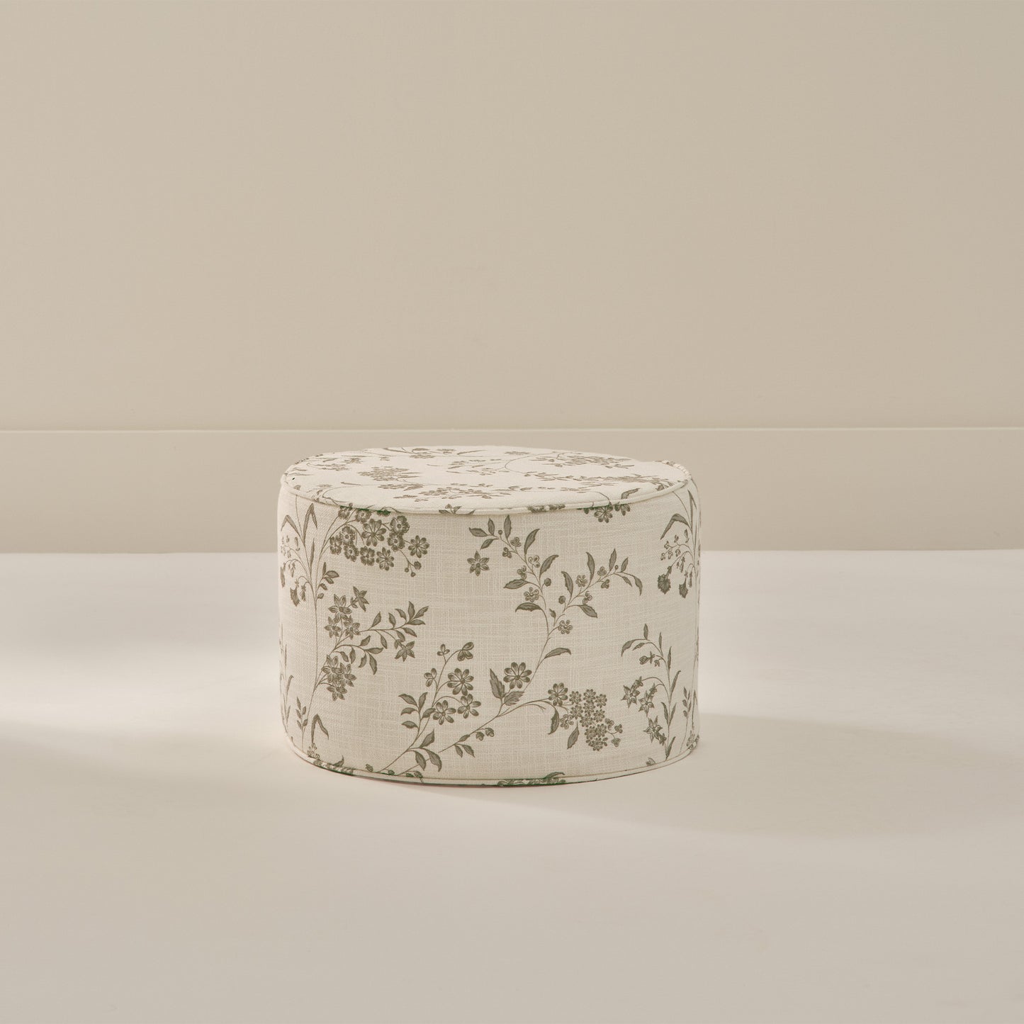 Small round foam ottoman with green and cream floral pattern from House of Noa