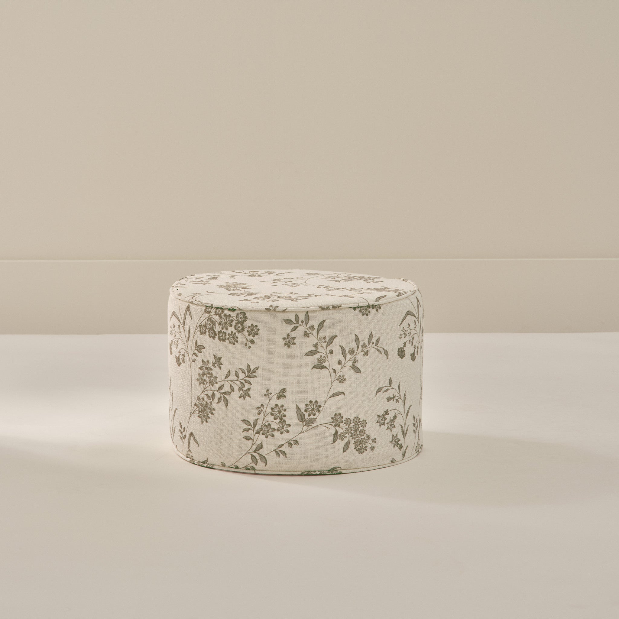 Small round foam ottoman with green and cream floral pattern from House of Noa