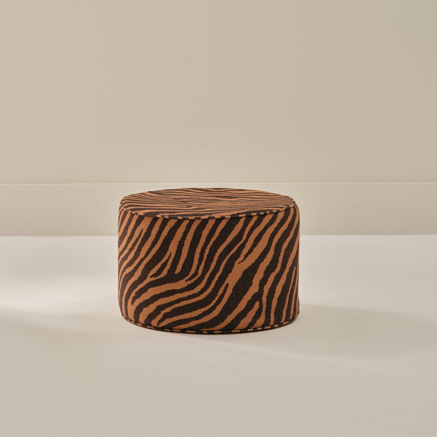 Small round foam ottoman in amber and sable zebra pattern from House of Noa