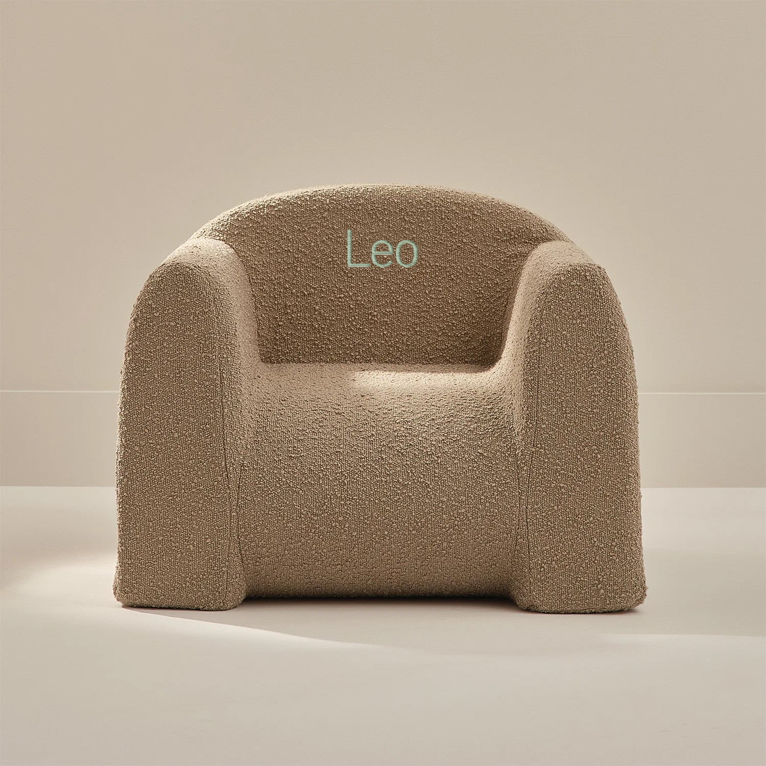 Beige textured armchair with 'Leo' embroidery on a neutral background