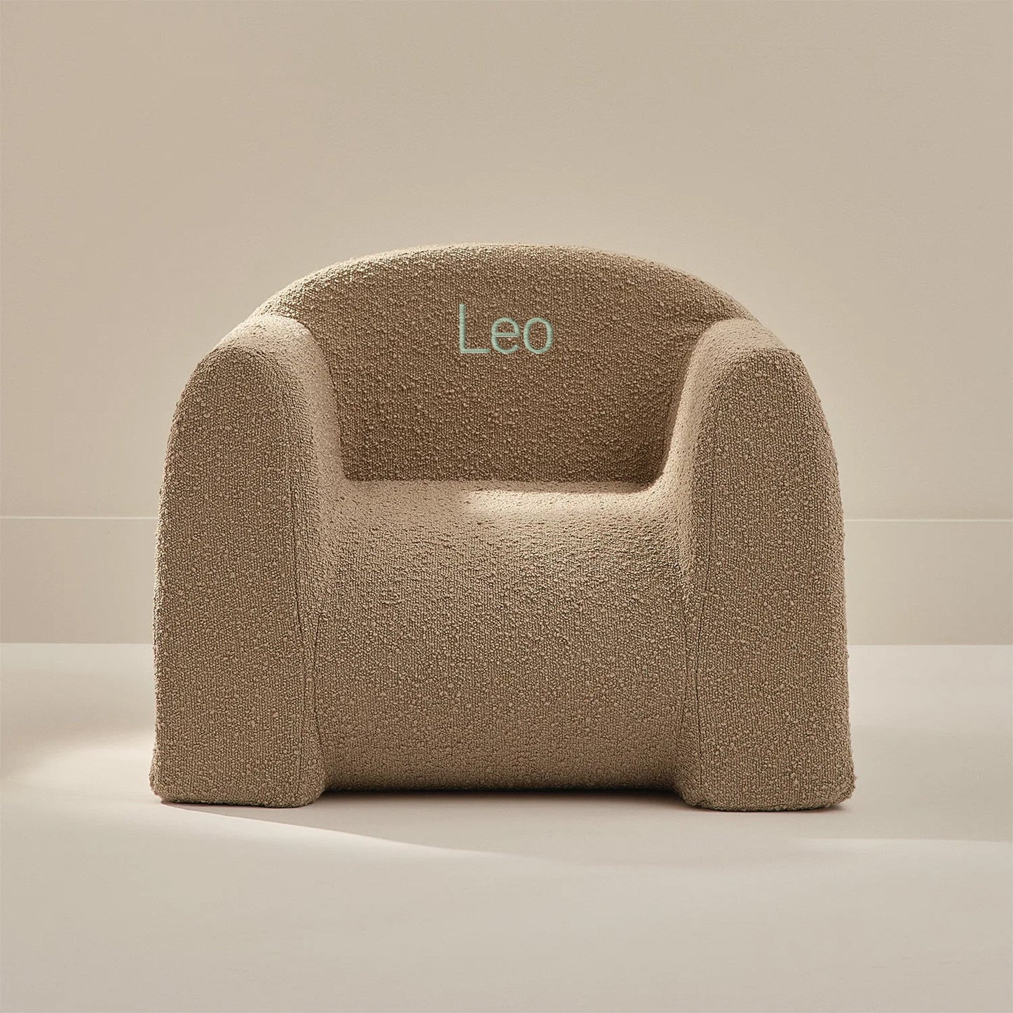 Beige textured armchair with 'Leo' embroidery on a neutral background