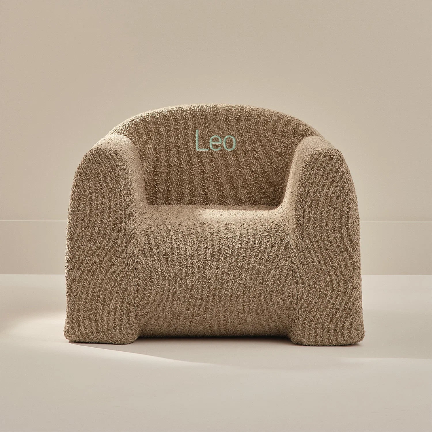 Beige textured armchair with 'Leo' embroidery on a neutral background