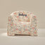 Floral-patterned chair with 'Bethany' embroidered on it against a beige background
