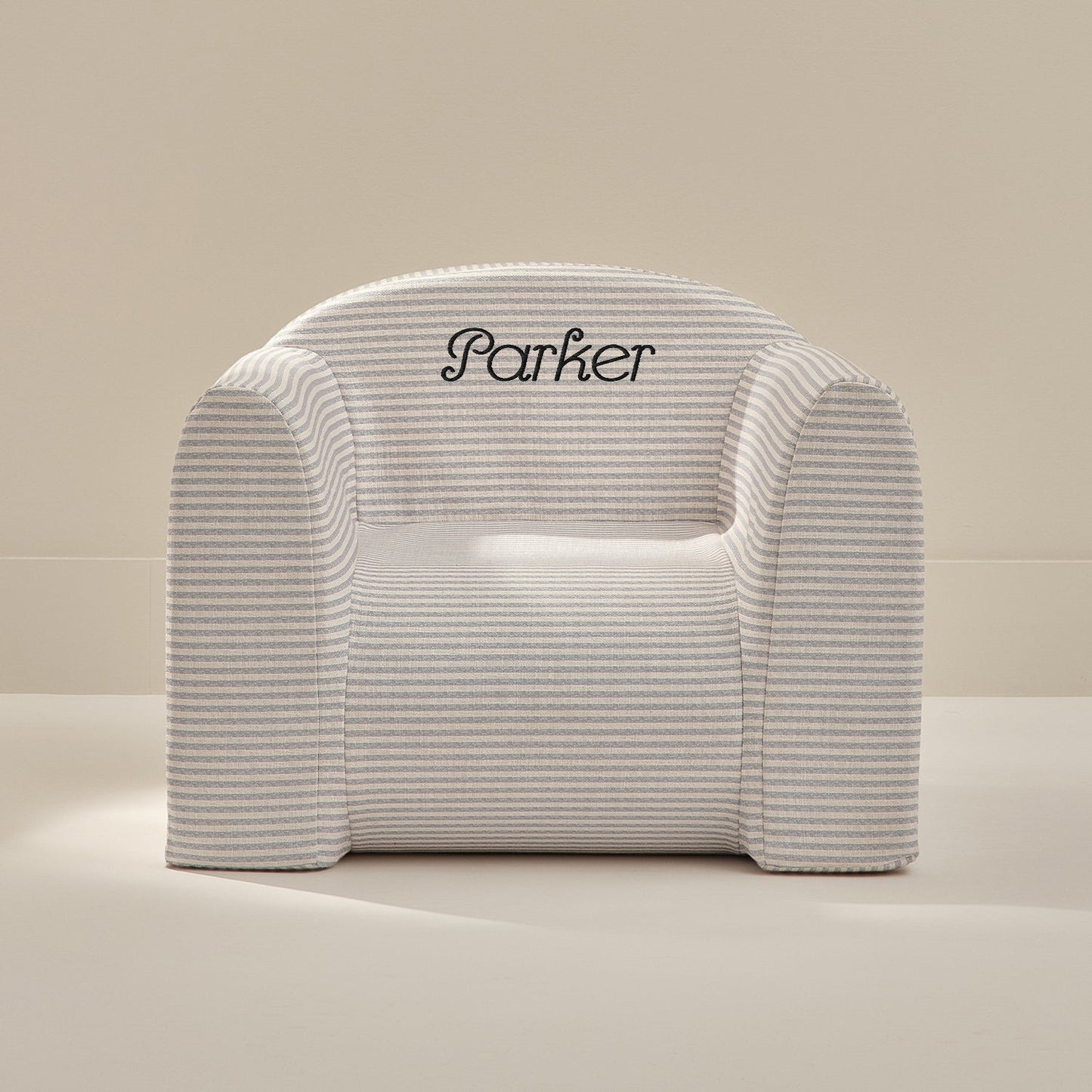White play chair with 'Parker' embroidery on a beige background