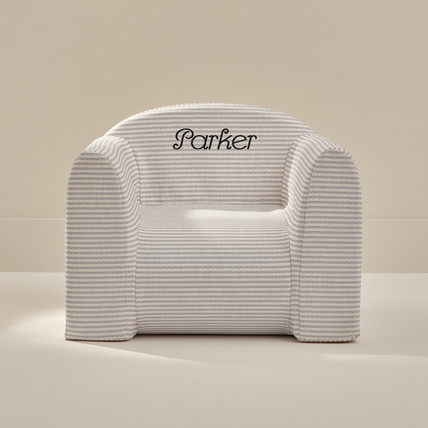 White play chair with 'Parker' embroidery on a beige background