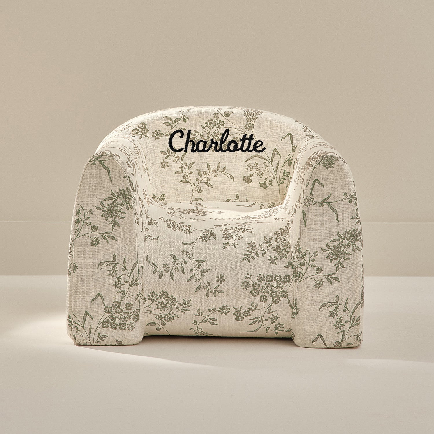 Floral-patterned chair with 'Charlotte' text on a beige background