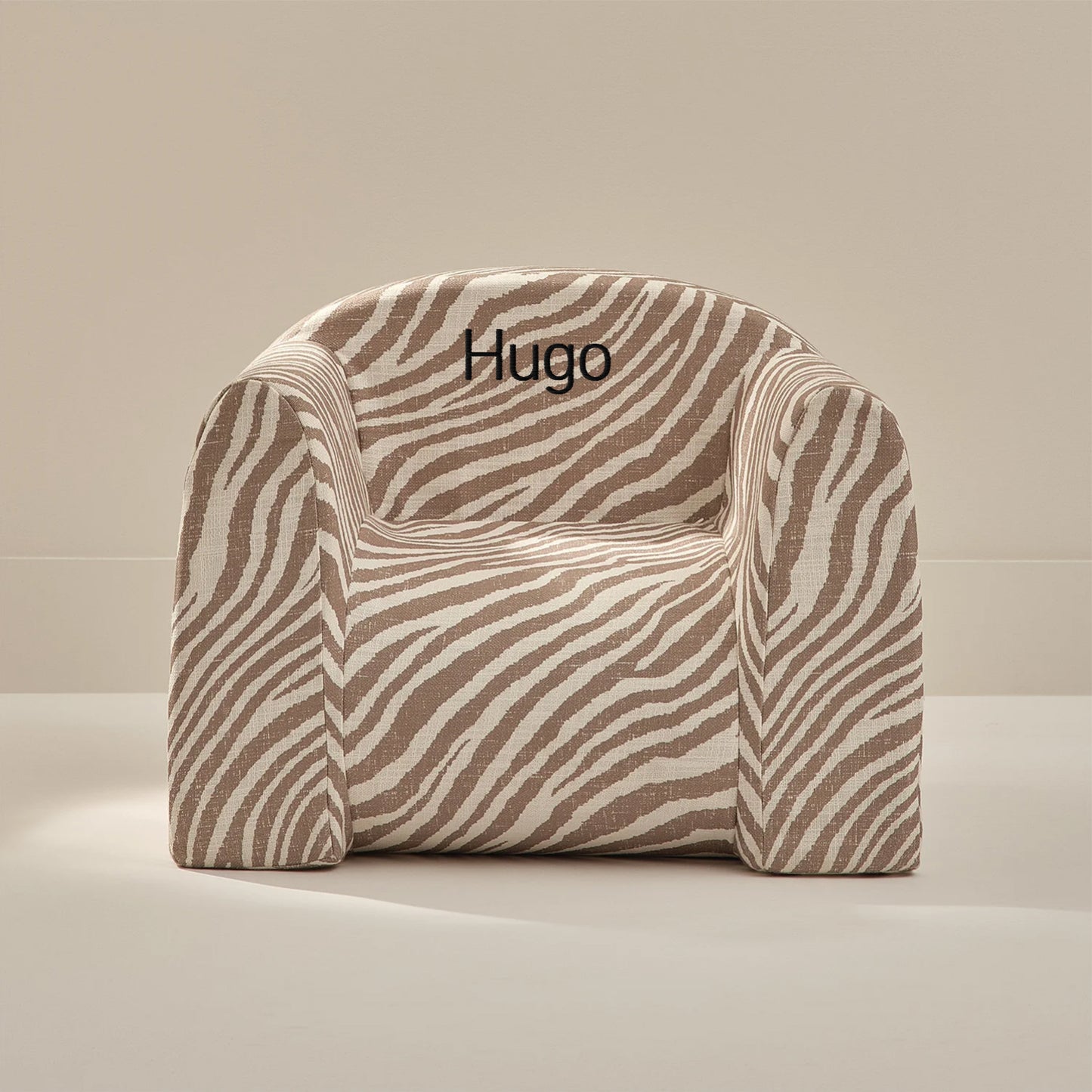 Zebra-patterned chair with 'Hugo' embroidery on a beige background