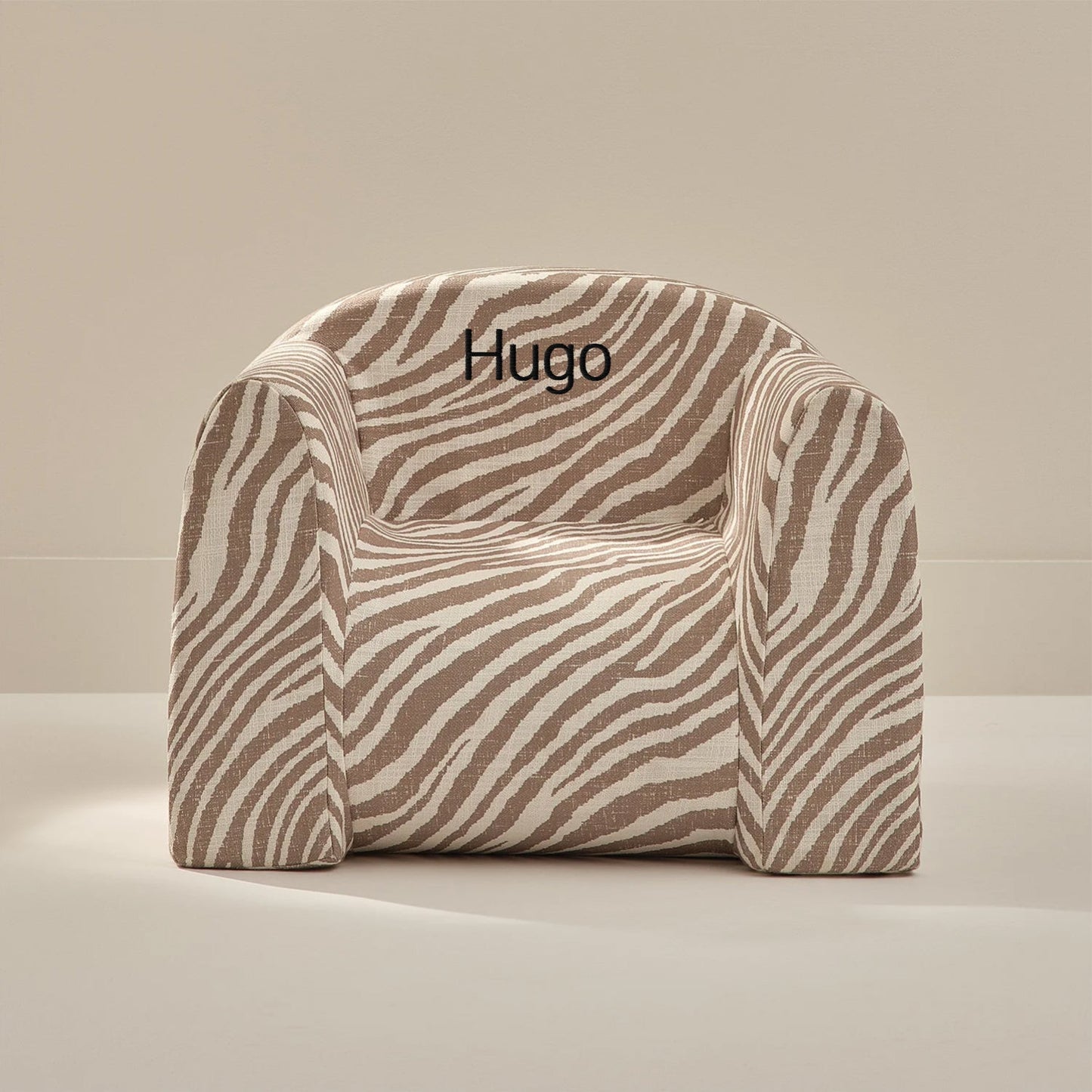 Zebra-patterned chair with 'Hugo' embroidery on a beige background