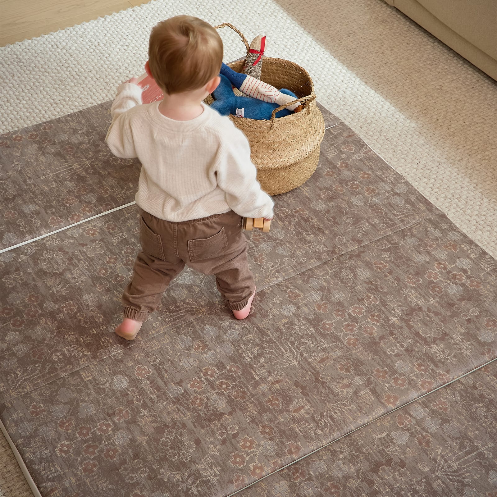Child playing with a basket on a patterned floor