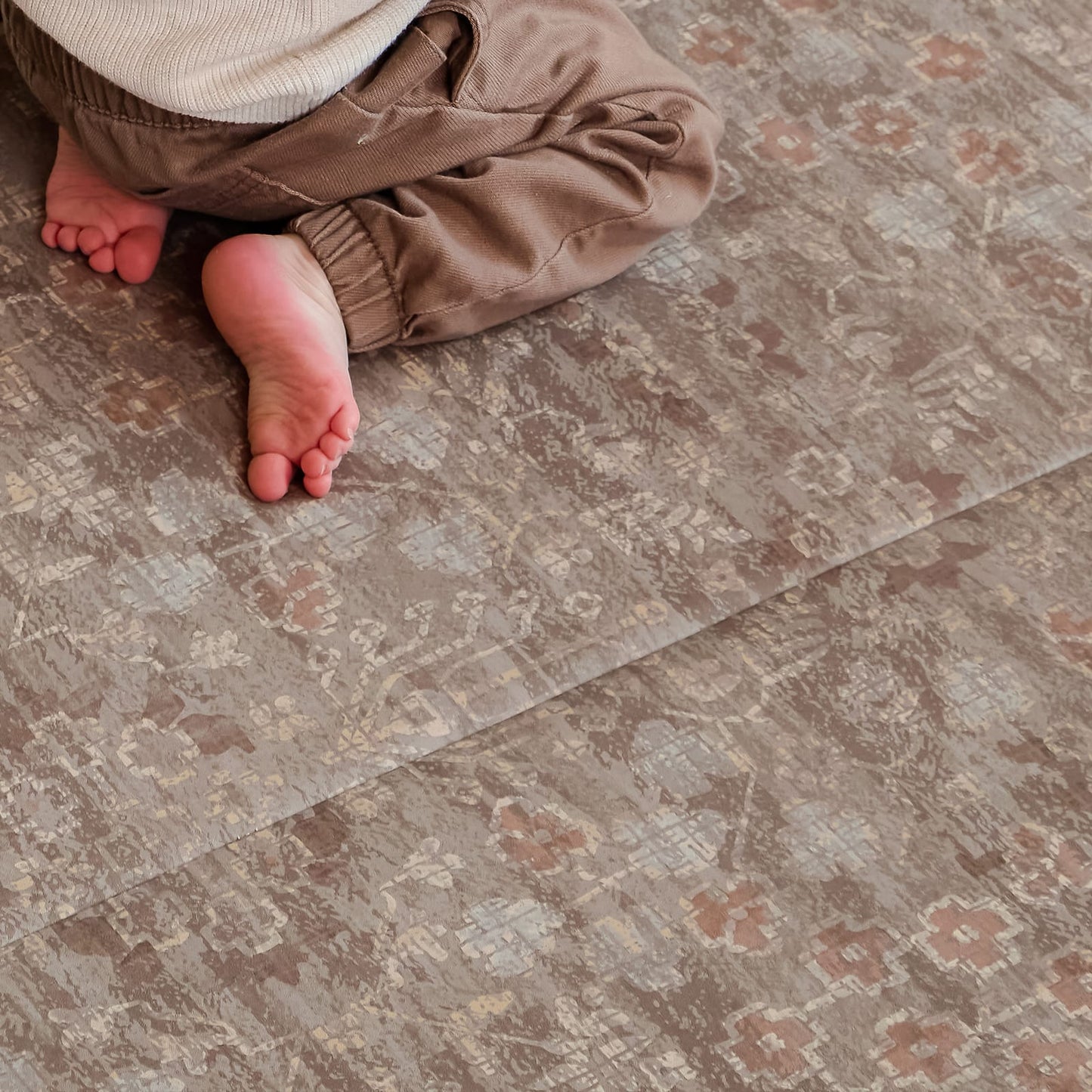 Close-up of a child's feet on a patterned floor