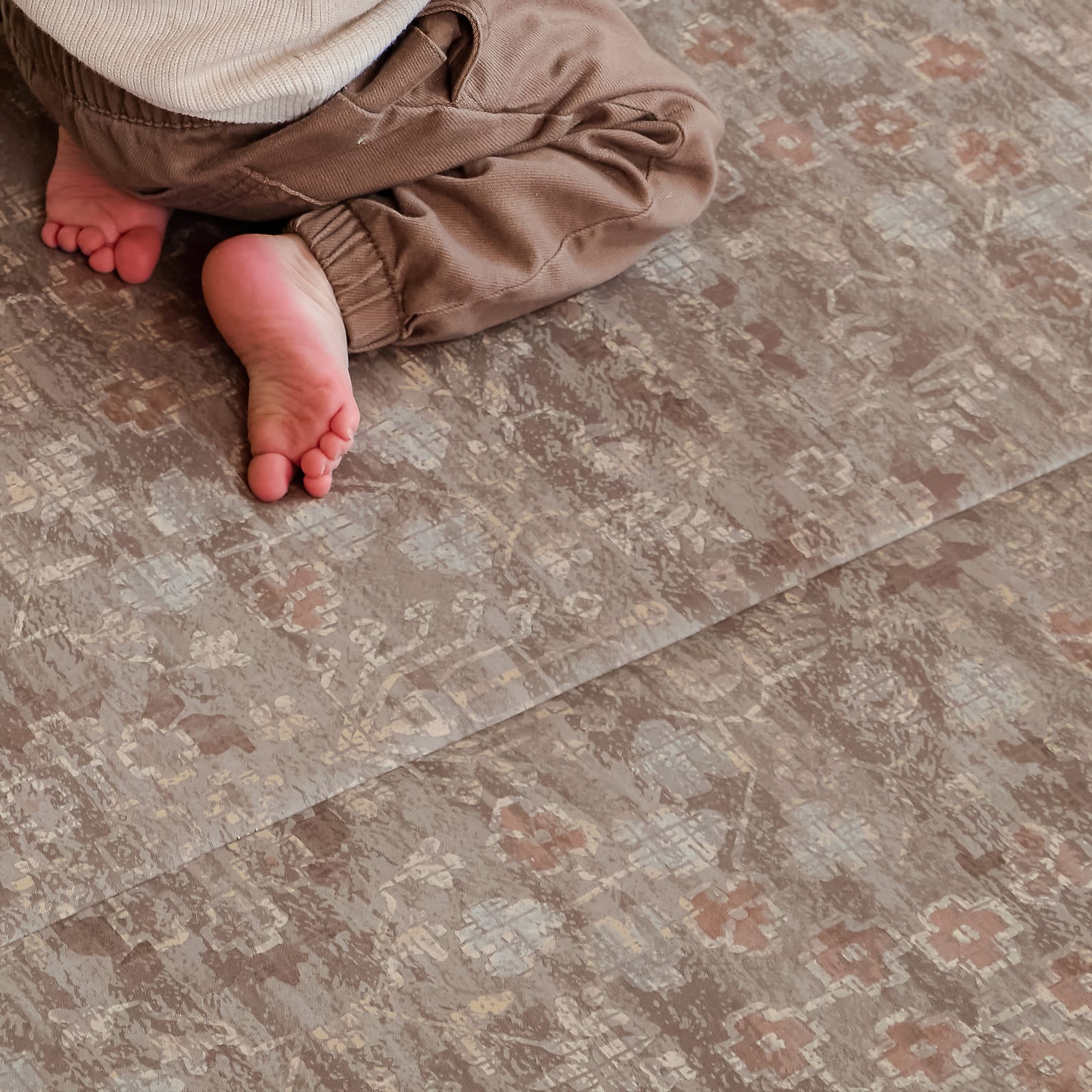 Close-up of a child's feet on a patterned floor