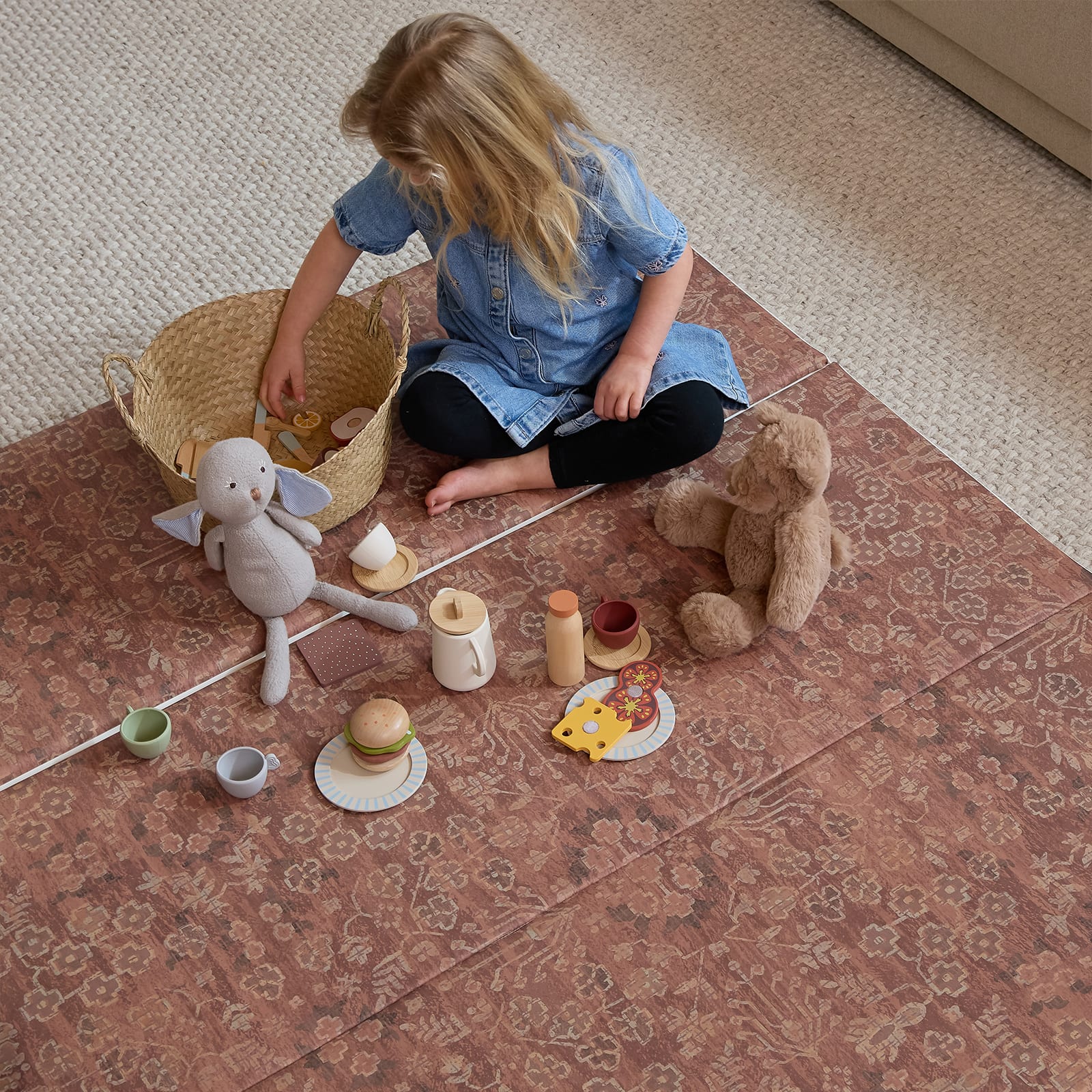 Child playing with toys on a patterned rug