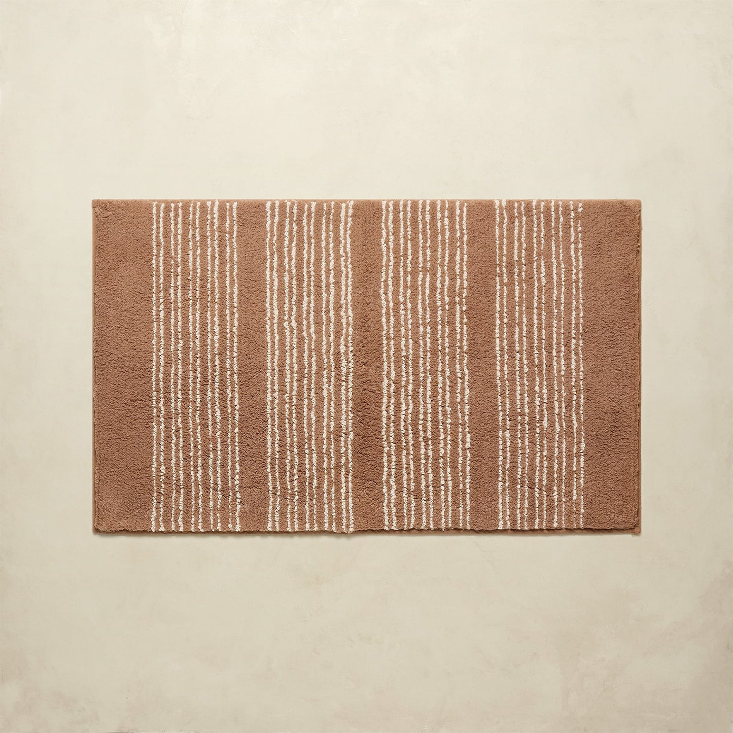 Rectangular brown rug with white stripes on a beige background