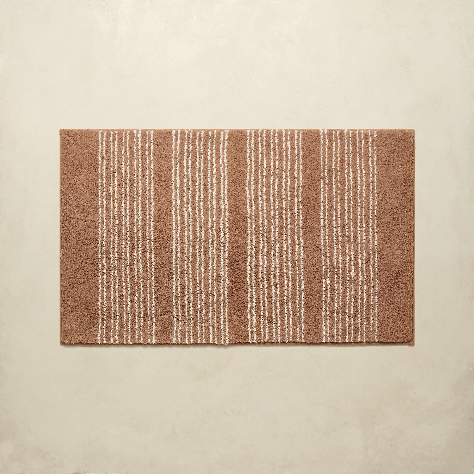 Rectangular brown rug with white stripes on a beige background