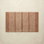 Rectangular brown rug with white stripes on a beige background