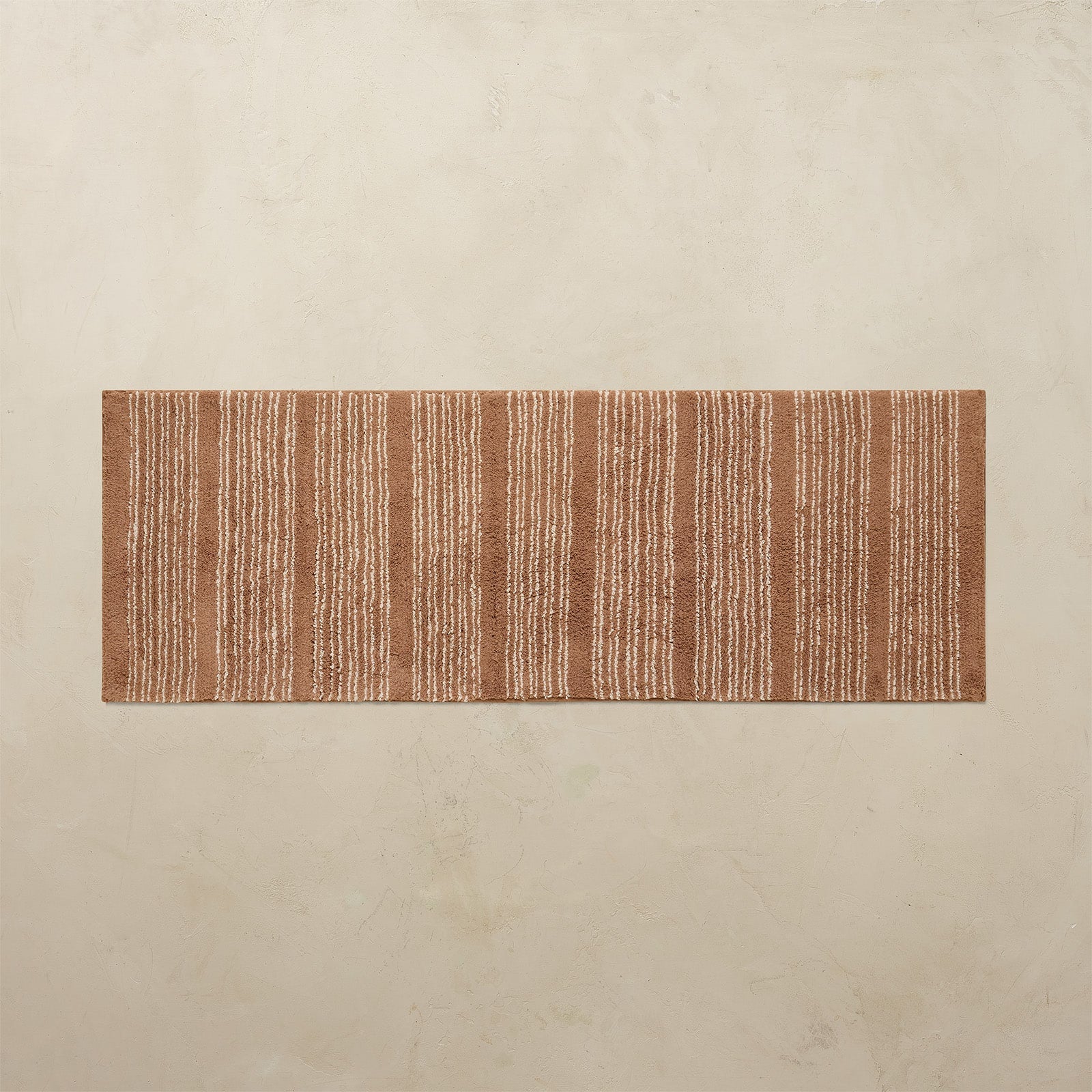 Rectangular brown rug on a beige floor