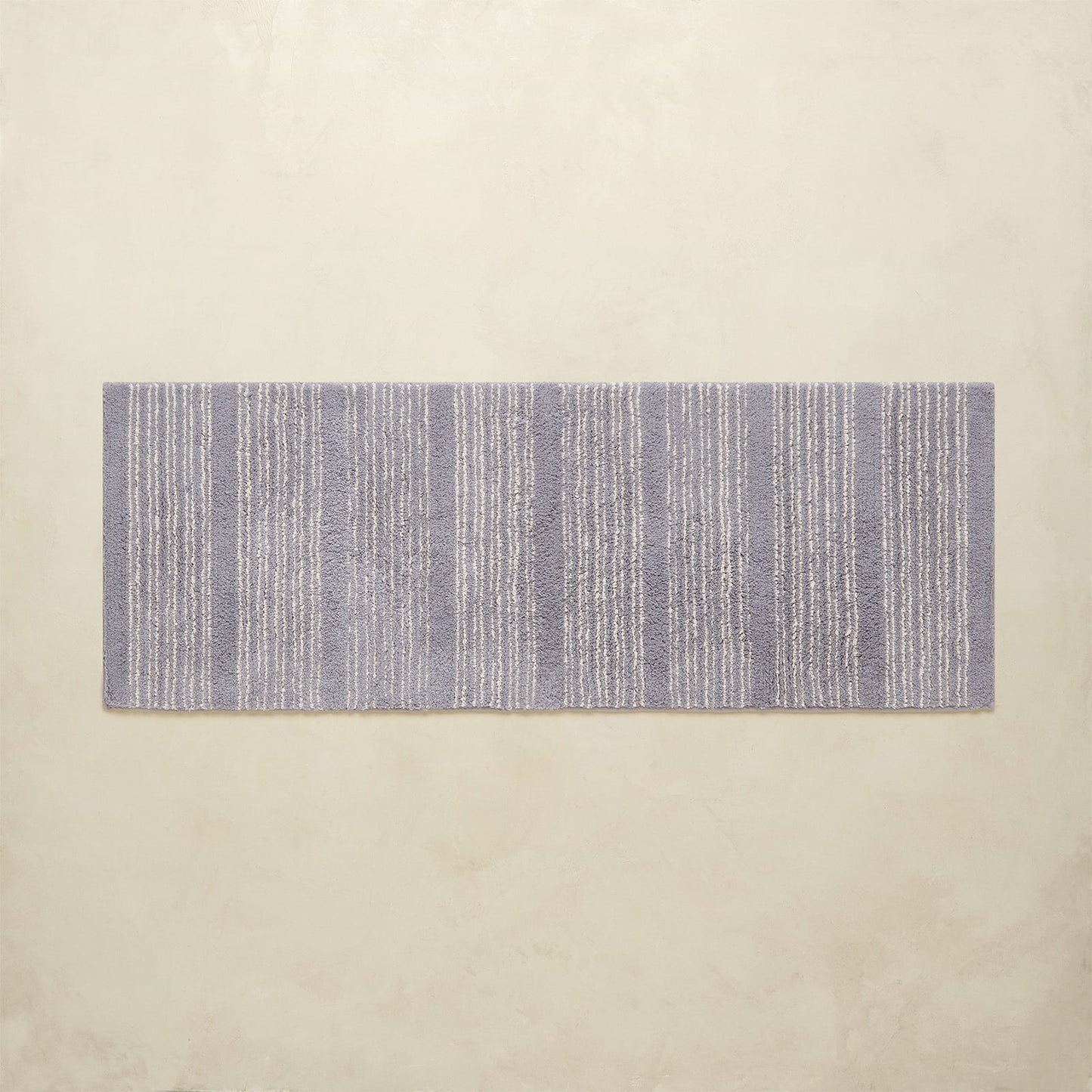Rectangular blue and white striped rug on a beige background