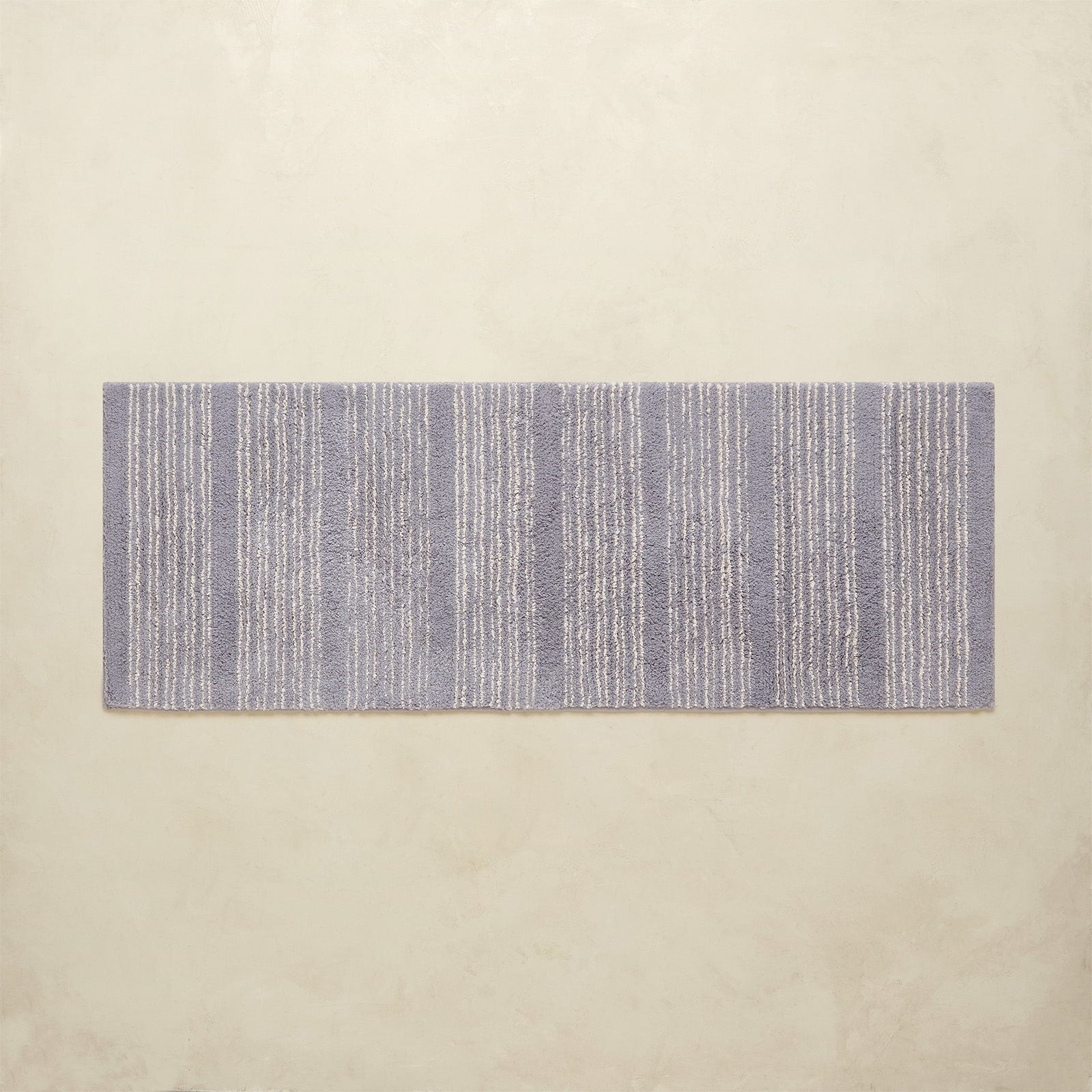 Rectangular blue and white striped rug on a beige background