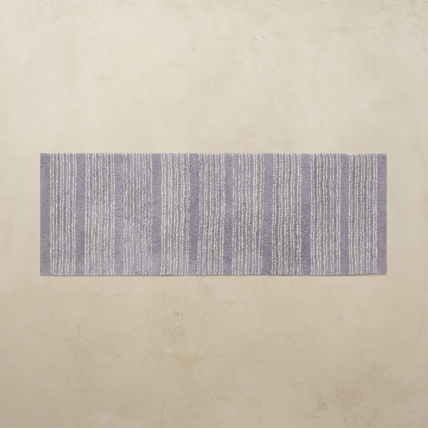 Rectangular blue and white striped rug on a beige background
