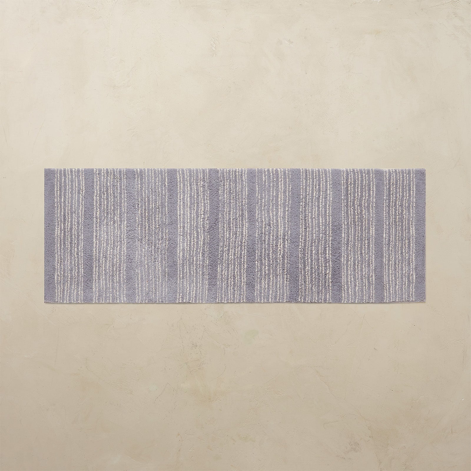 Rectangular blue and white striped rug on a beige background