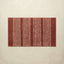Rectangular red rug with white stripes on a beige background