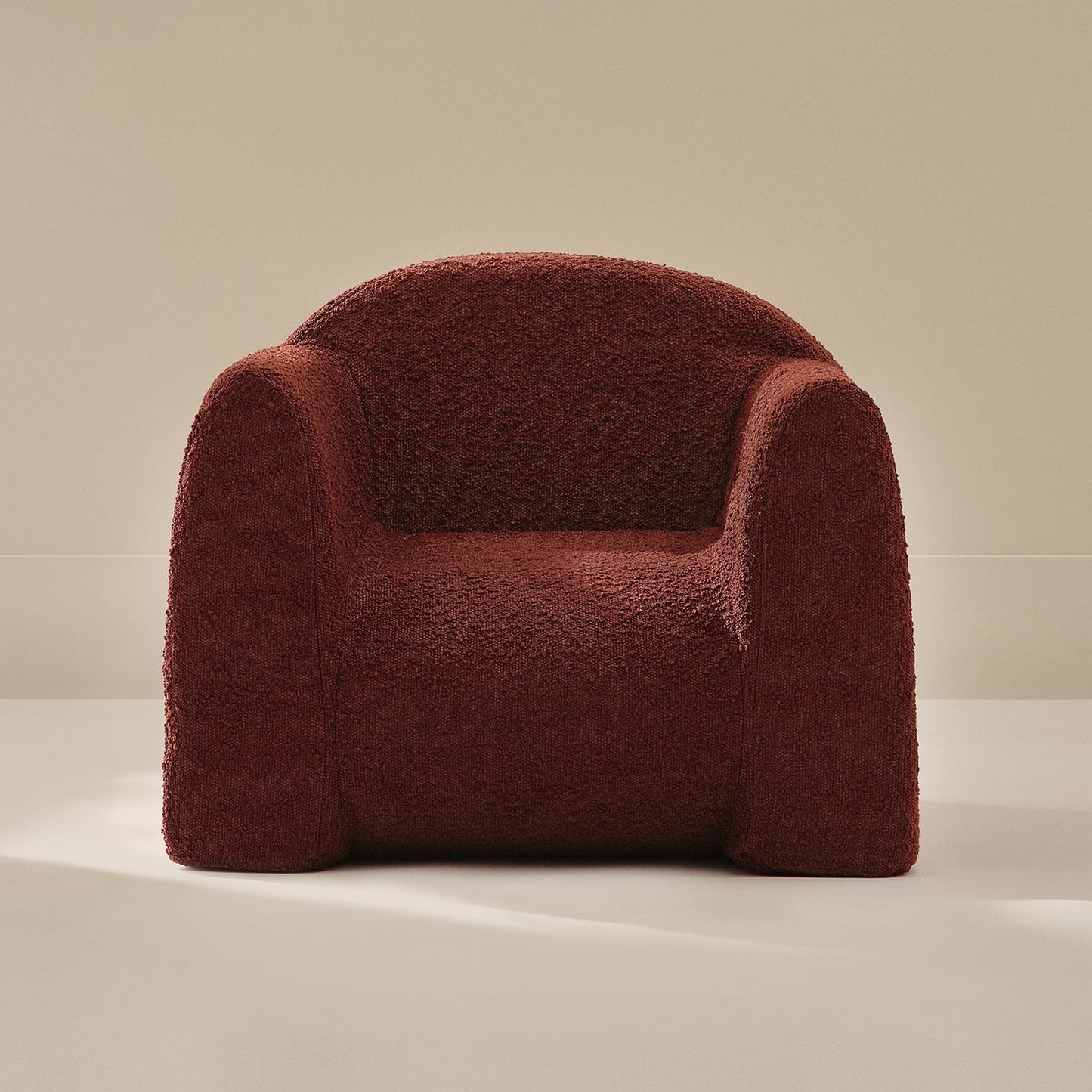 Red boucle armchair on a beige background
