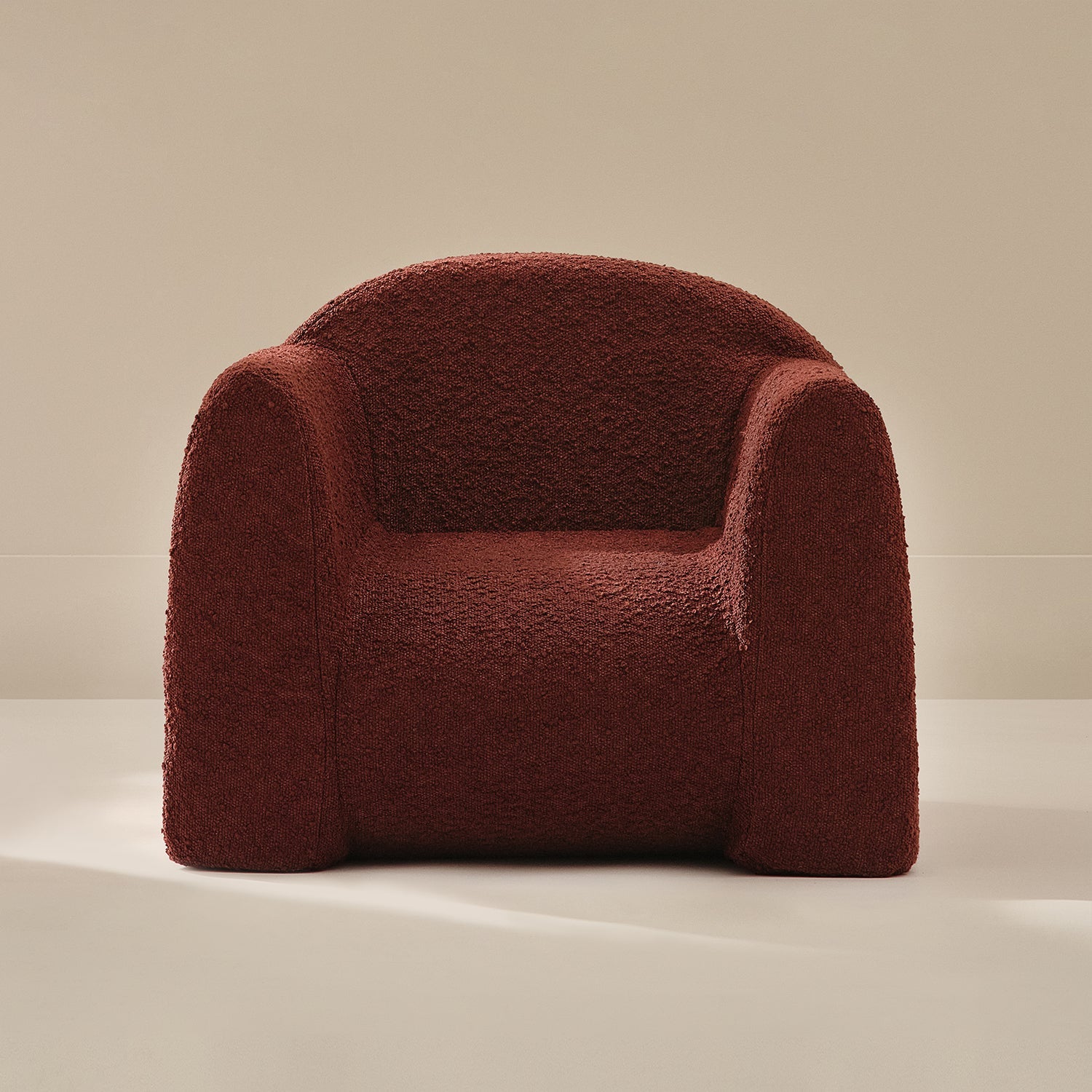 Red boucle armchair on a beige background