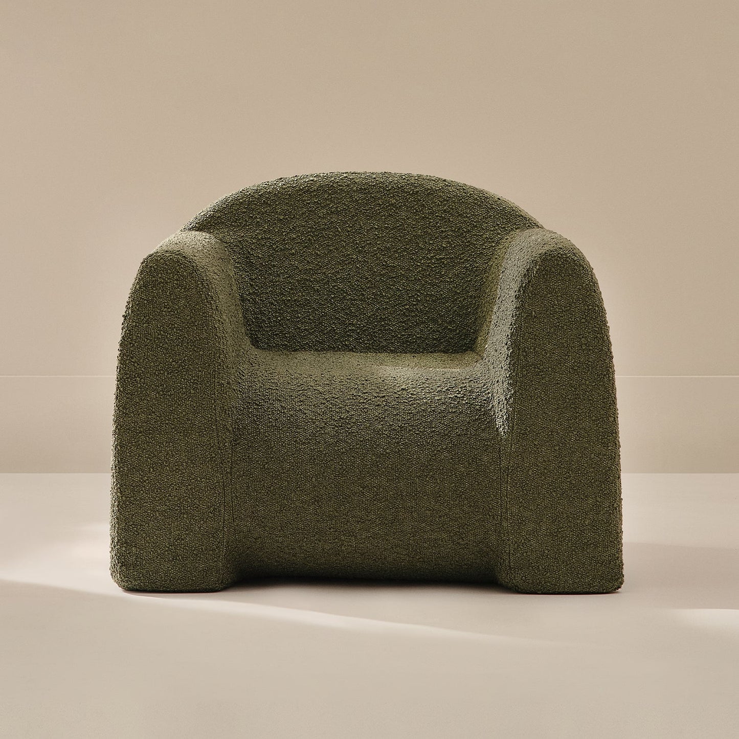 Green textured armchair on a beige background