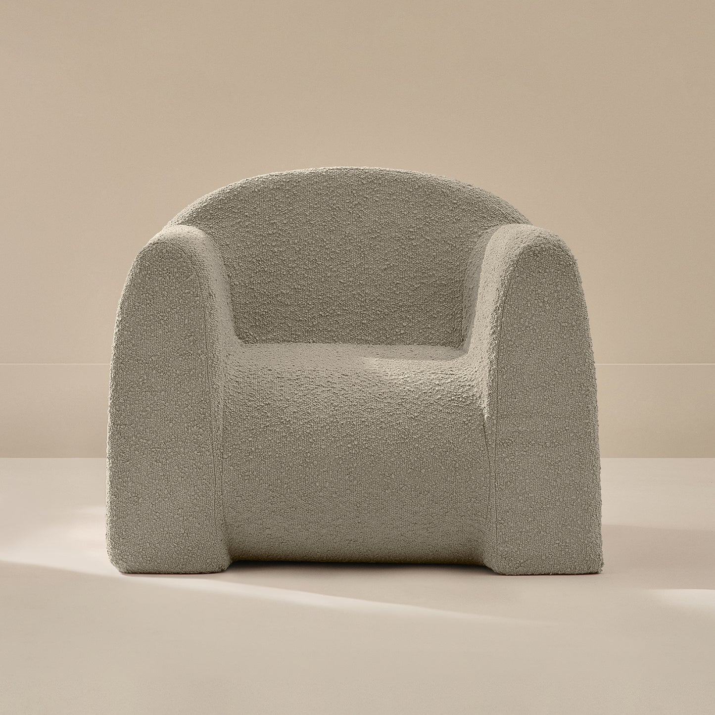 Light gray textured armchair on a beige background