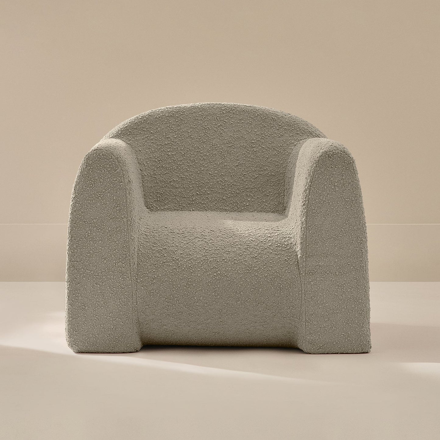 Light gray textured armchair on a beige background