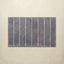 Rectangular bath mat with vertical stripes on a beige background