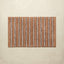 Striped bath mat with brown and beige stripes on a beige background