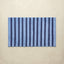 Striped blue bath rug with vertical lines on a beige background