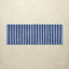 Rectangular blue and navy striped bath rug on a beige background