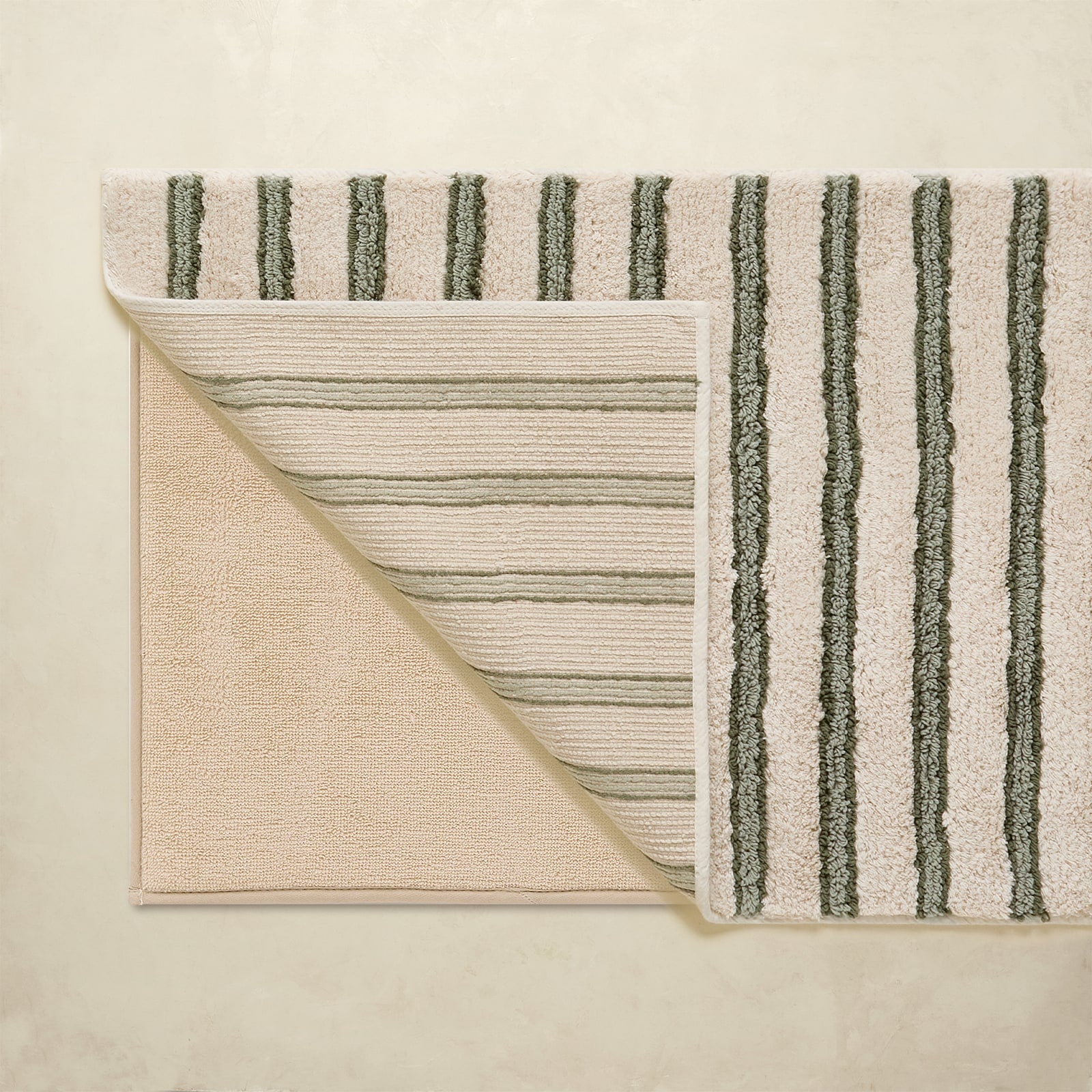 Striped rug with green and beige colors on a beige background