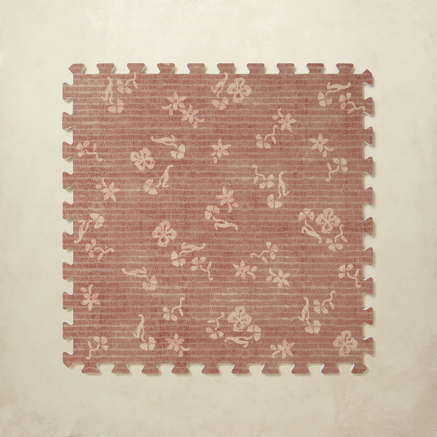 Floral patterned foam puzzle mat on a beige background